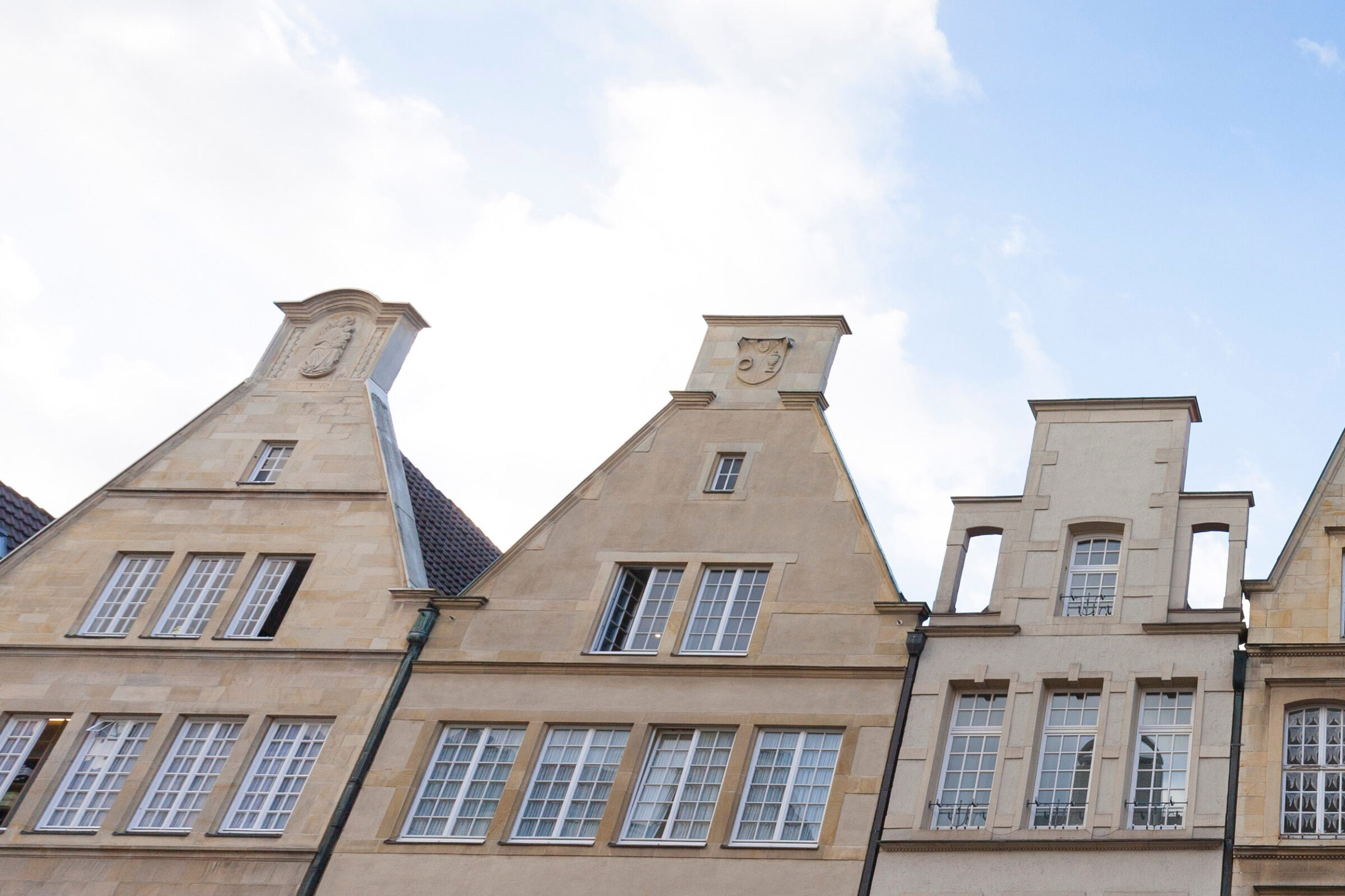 Mieteinnahmen versteuern: Alte Hausfassaden aus der Froschperspektive mit blauem Himmel im Hintergrund