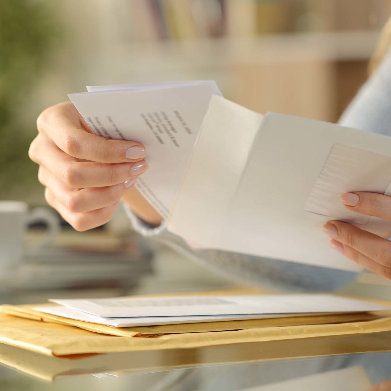 Kündigungsbestätigung: Frau legt Brief in einen Umschlag